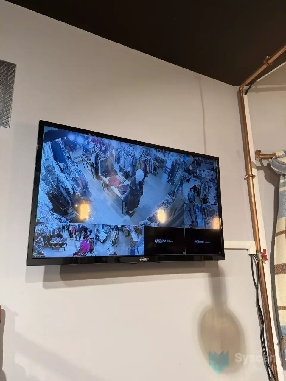 Écran de contrôle mural Dahua affichant en mosaïque les images des caméras de la boutique